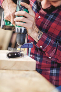 side view of a man drilling a hole in to a part of a bicycle&hellip;